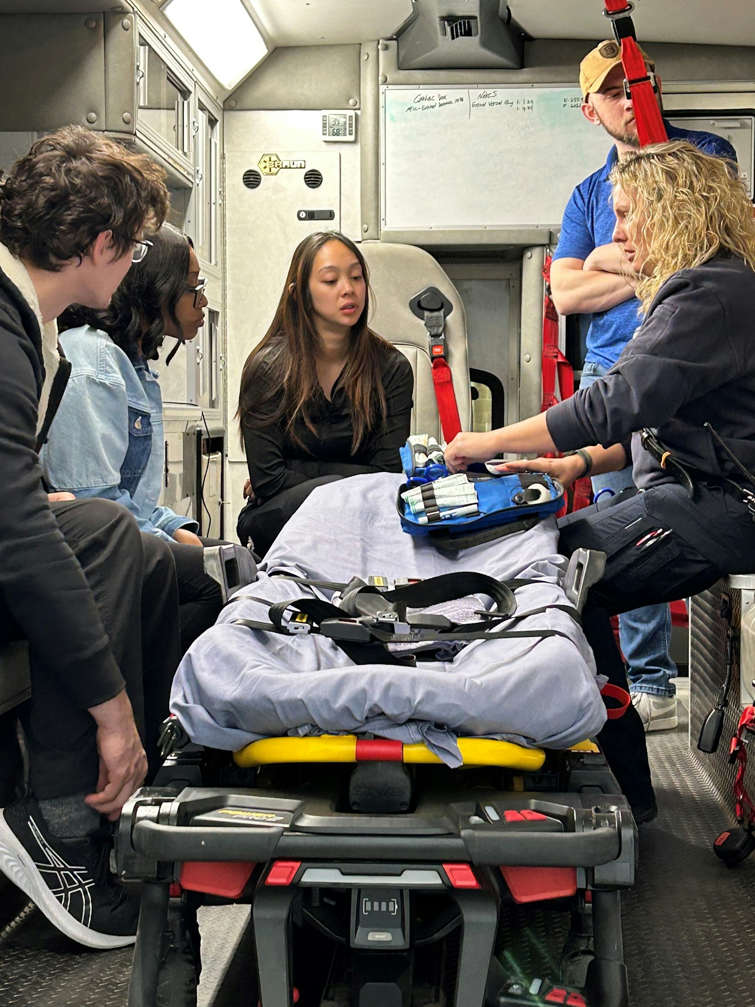 An ambulance interior with EMTs and patients during training or medical assistance.