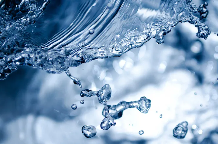 The image features an artistic close-up of water, showcasing splashes and droplets with a blue tone and smooth motion.