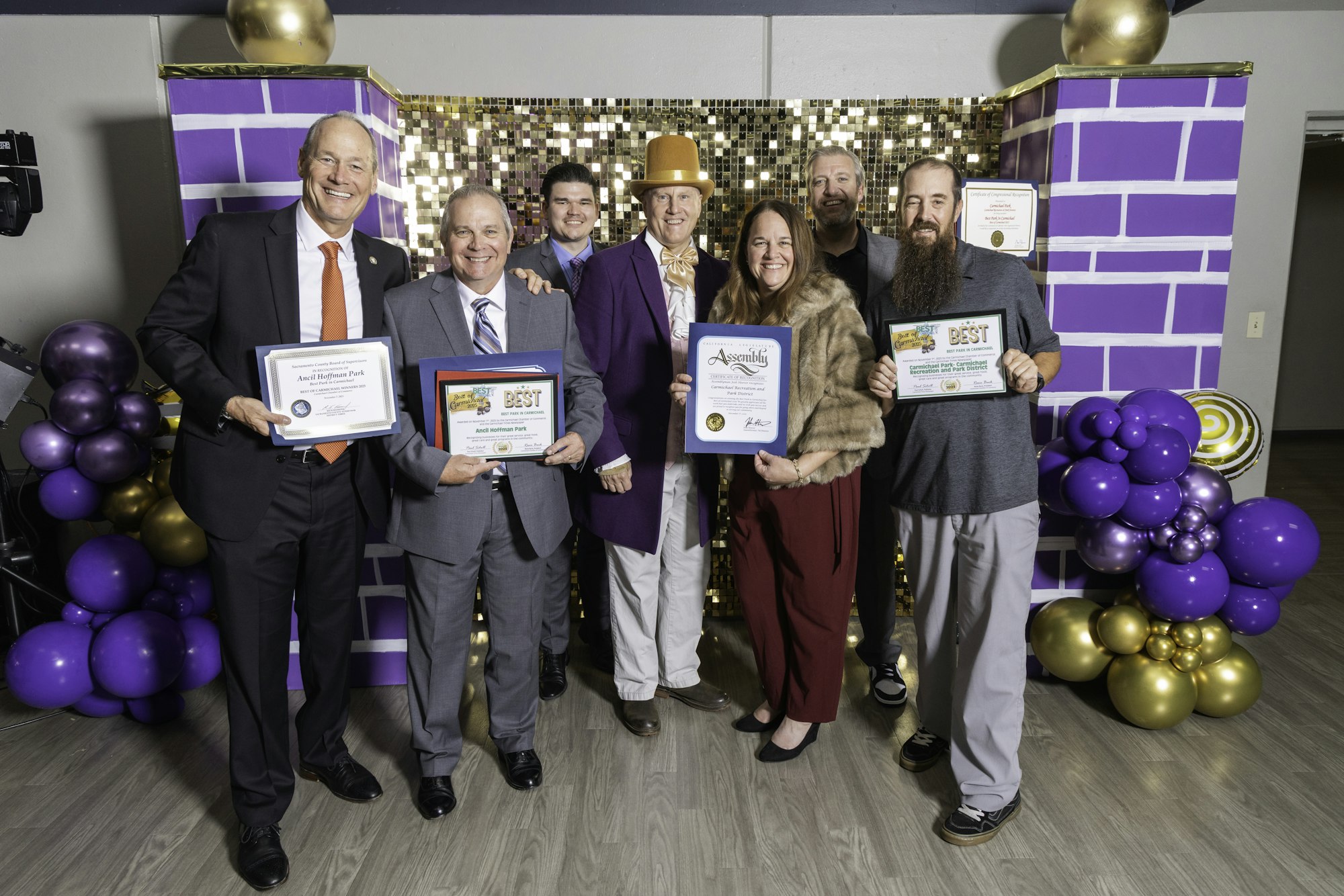 May contain: people, person, purple, adult, female, woman, groupshot, clothing, footwear, shoe, balloon, male, man, accessories, formal wear, tie, and hat