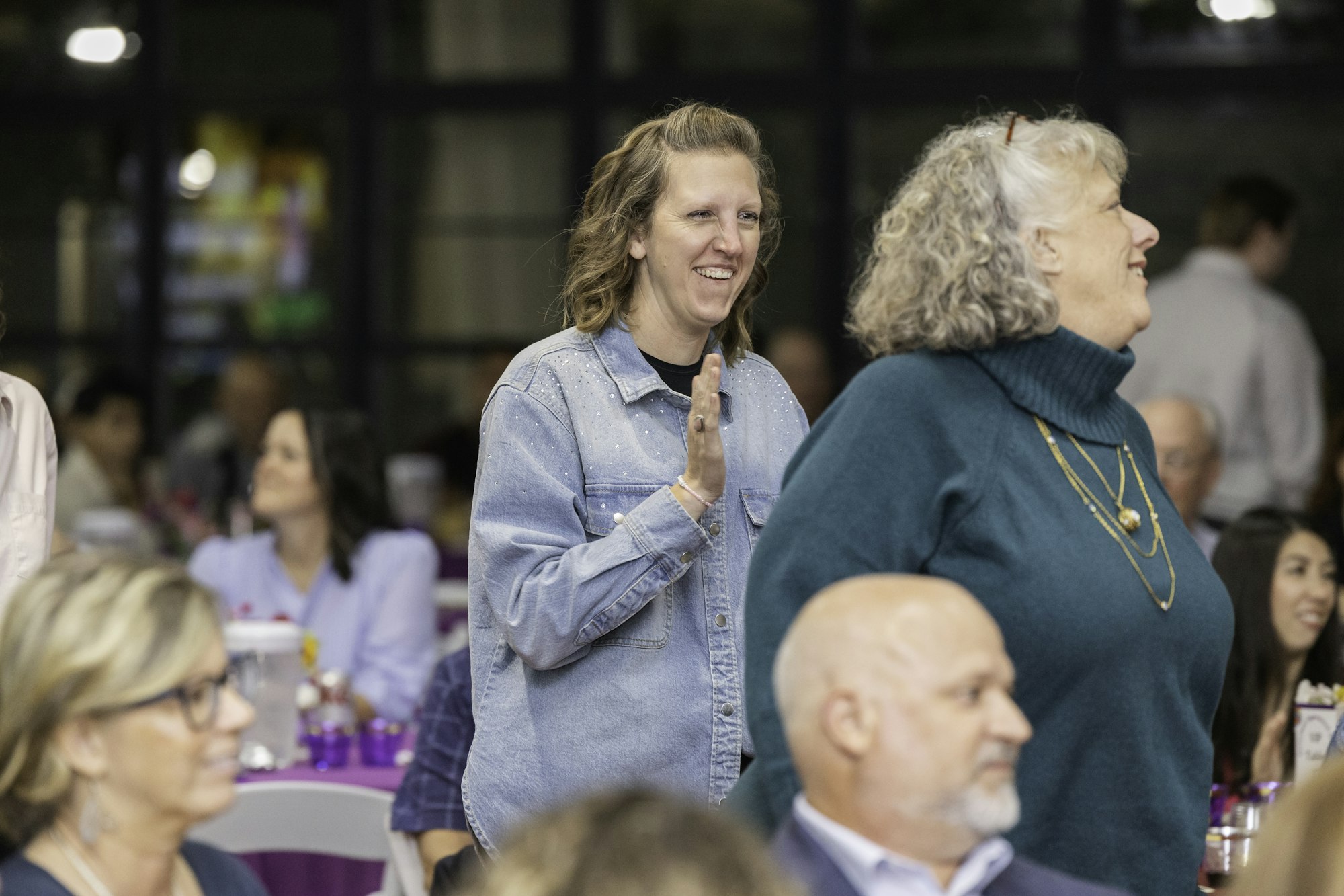People attending an indoor event, chatting and smiling.