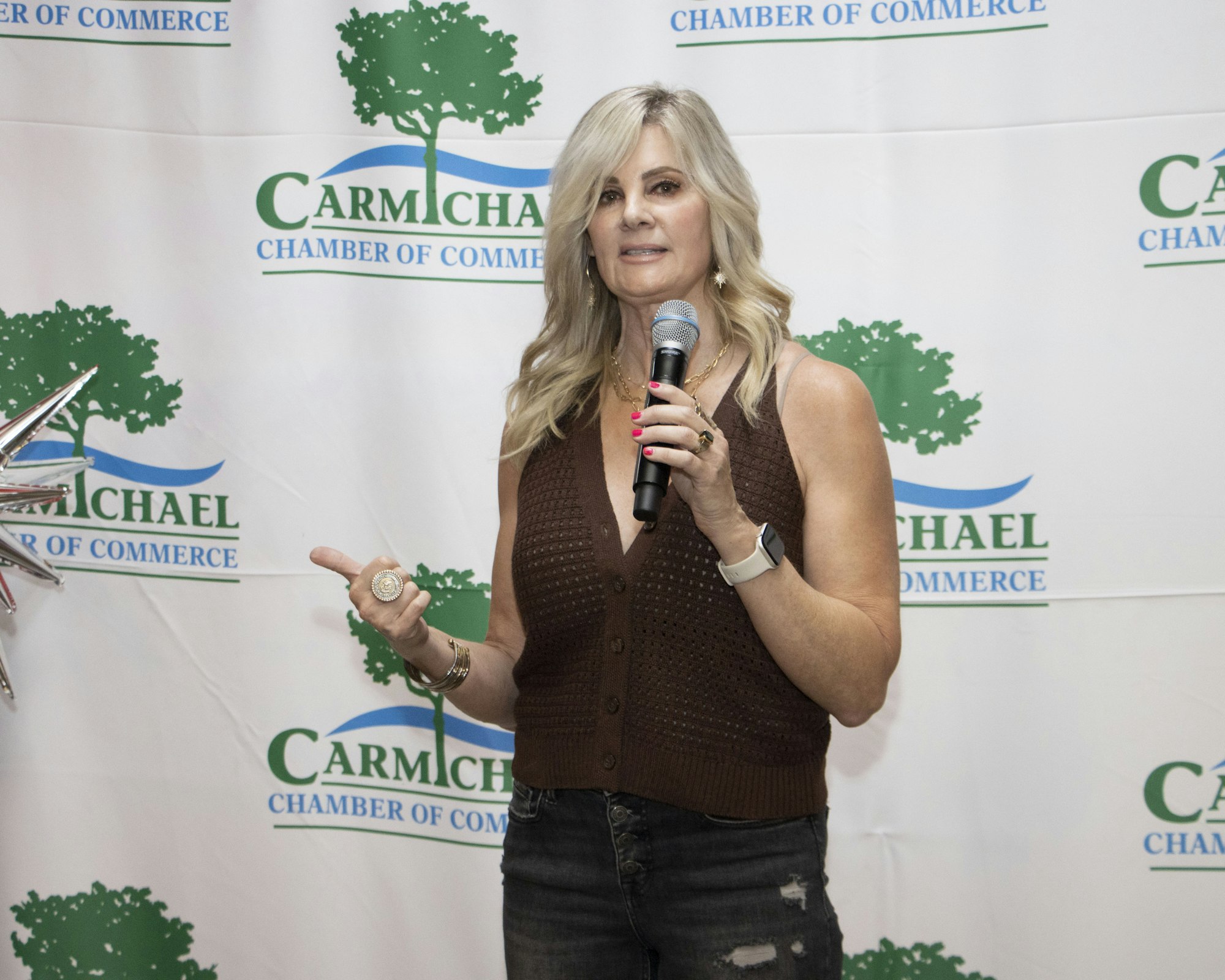 A person speaking into a microphone at a Carmichael Chamber of Commerce event.
