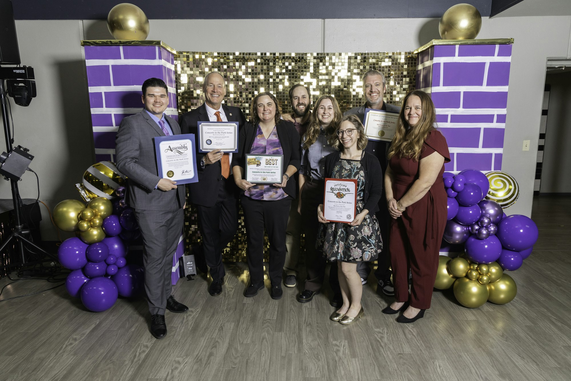 May contain: people, person, groupshot, adult, female, woman, purple, clothing, footwear, shoe, male, man, accessories, formal wear, tie, wristwatch, glasses, balloon, and helmet