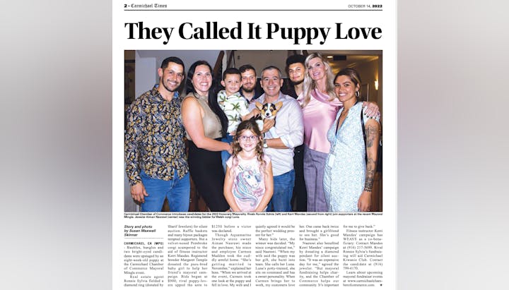 A group of people smiling with a corgi puppy at a community event, under the headline "They Called It Puppy Love."