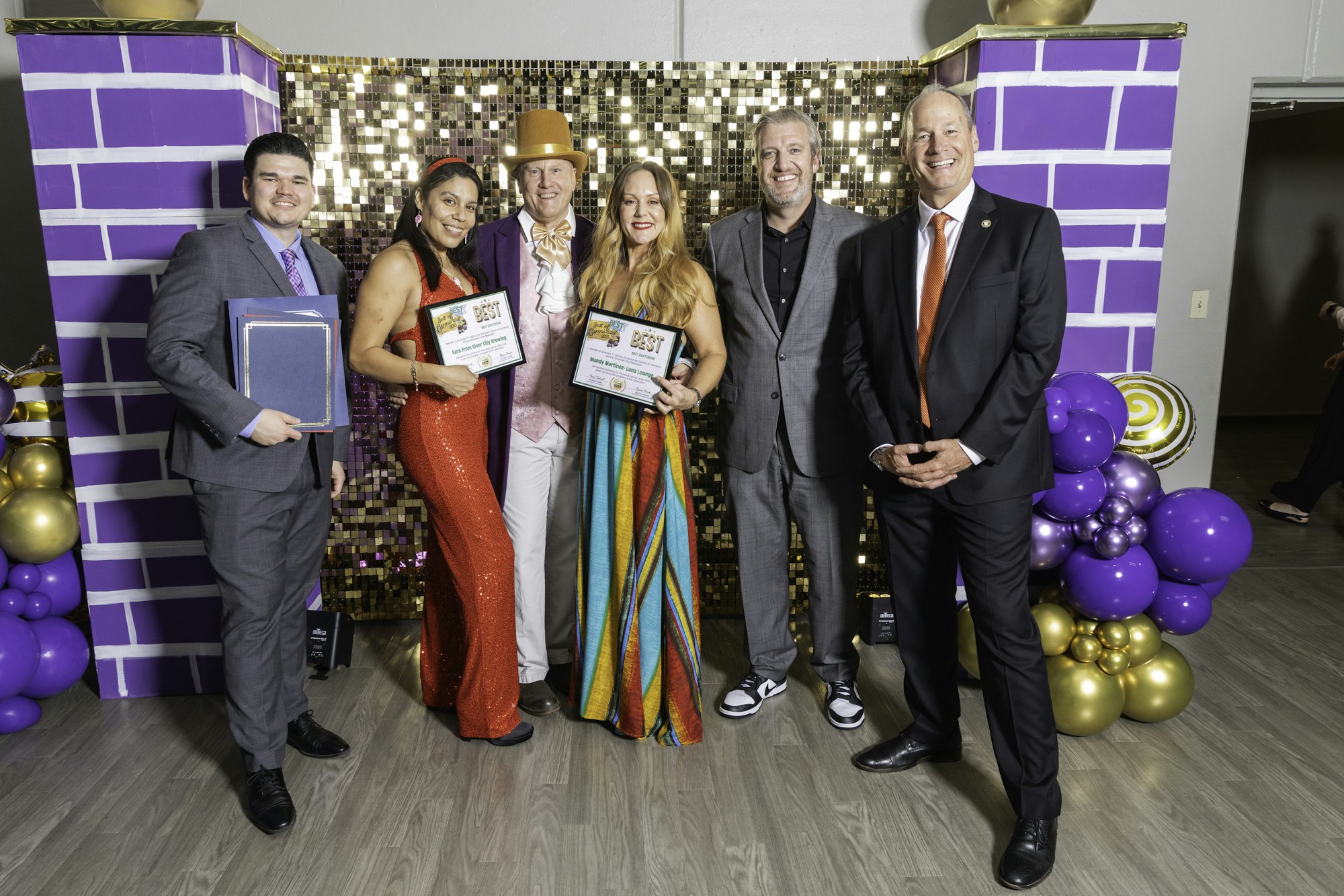 May contain: groupshot, person, clothing, footwear, shoe, adult, female, woman, people, accessories, formal wear, tie, male, man, balloon, hat, and purple