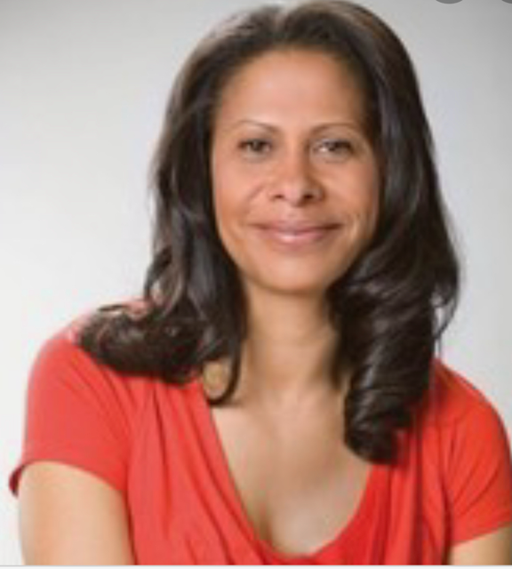 A smiling woman in a red top against a grey background.