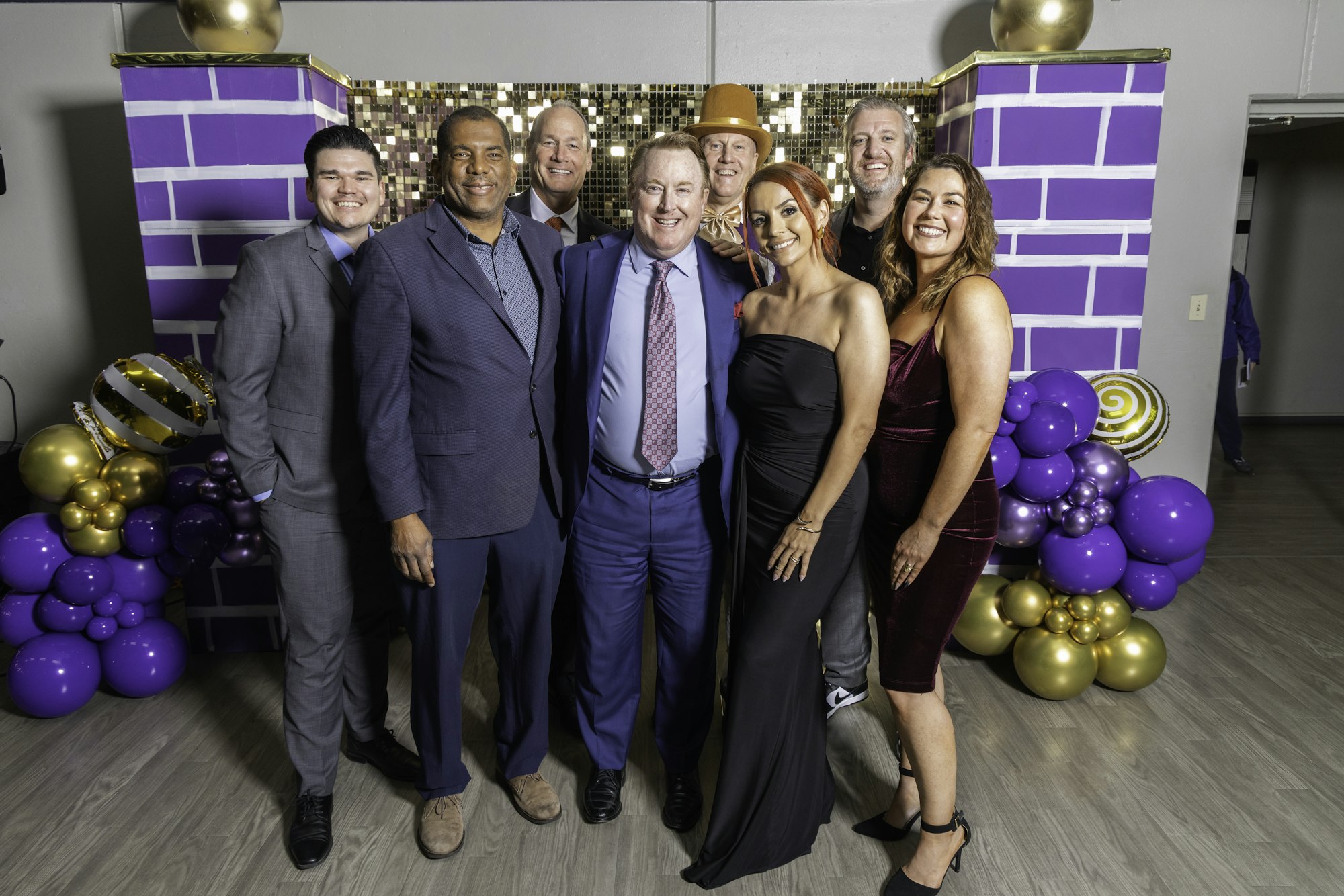 May contain: groupshot, person, people, purple, adult, female, woman, clothing, footwear, shoe, accessories, formal wear, tie, male, man, high heel, hat, belt, and helmet