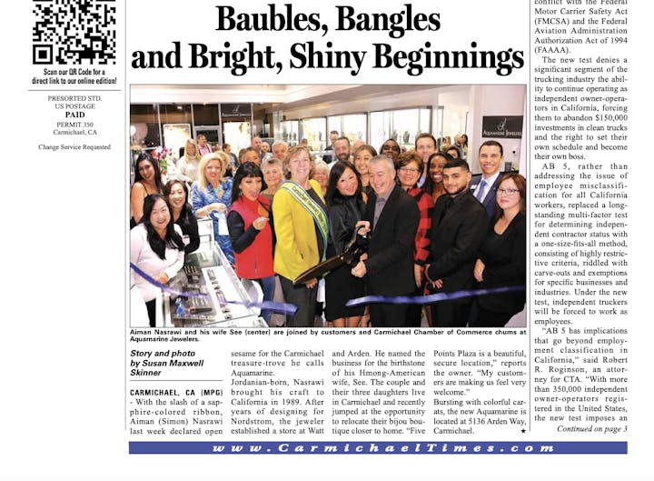A group of people at a ribbon-cutting event for Aquamarine Jewelers.