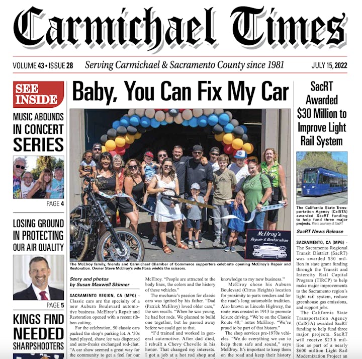 A newspaper cover with headlines about a car repair shop opening and a $30 million light rail system grant. Features a group photo.