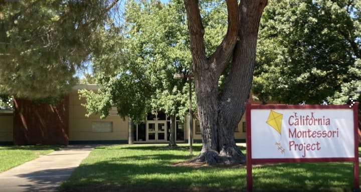The image shows a school building surrounded by trees, with a prominent sign for the "California Montessori Project."
