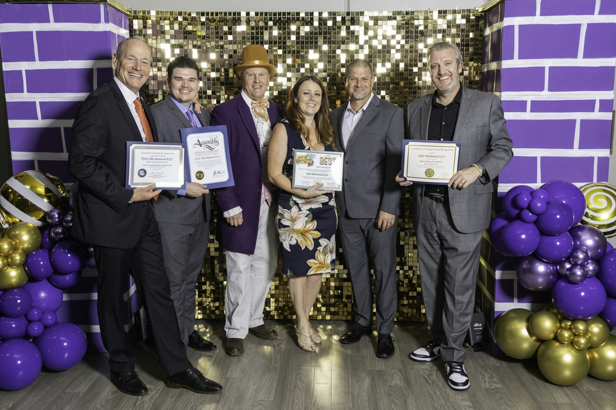 May contain: people, person, purple, clothing, footwear, shoe, adult, male, man, female, woman, groupshot, balloon, helmet, accessories, formal wear, tie, hat, and belt