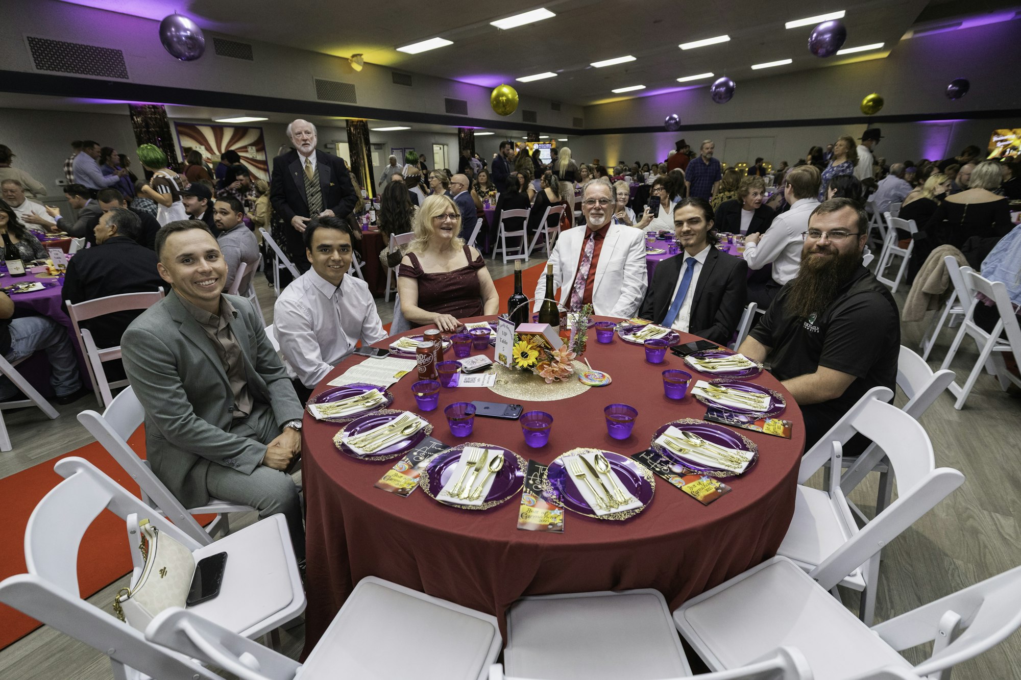 May contain: adult, female, person, woman, cup, male, man, indoors, accessories, formal wear, tie, people, fun, electronics, mobile phone, phone, plate, glasses, urban, wristwatch, clothing, footwear, and shoe