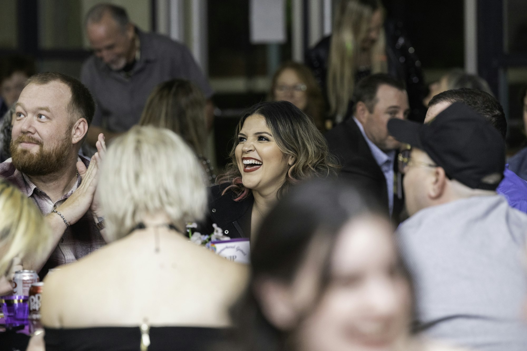 A group of people are sitting and laughing at a social gathering.