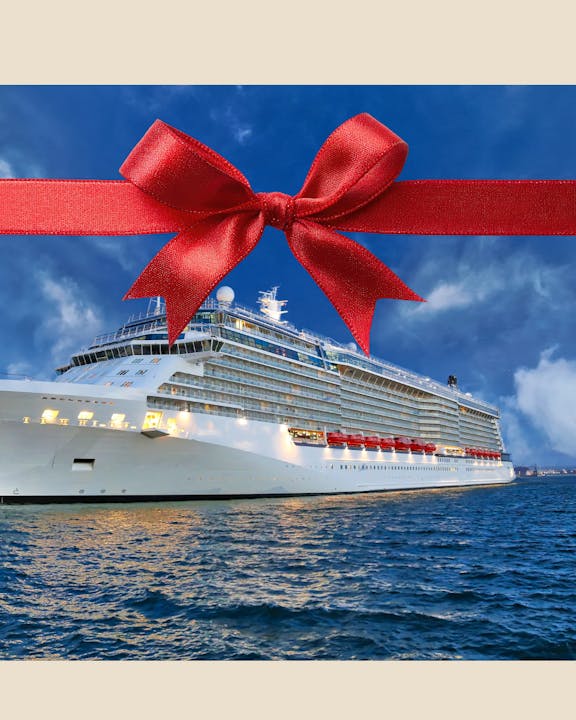 A large cruise ship on water, adorned with a red bow, suggesting it’s a special gift or celebration.