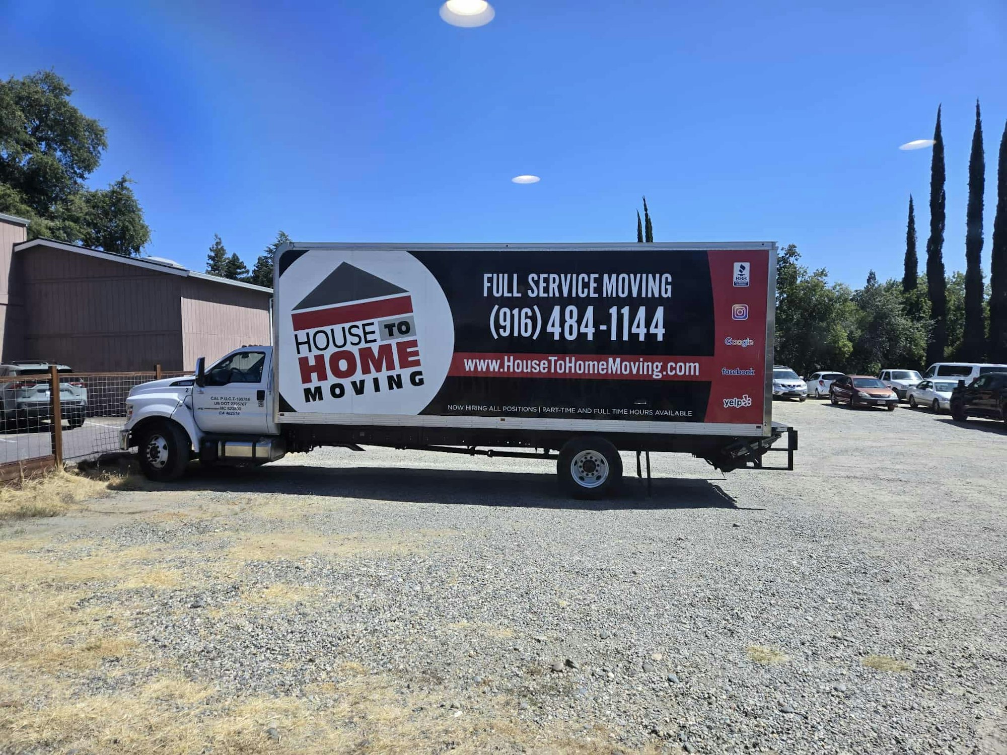 A moving truck with "House to Home Moving" services, contact number, and website is parked on a gravel lot.