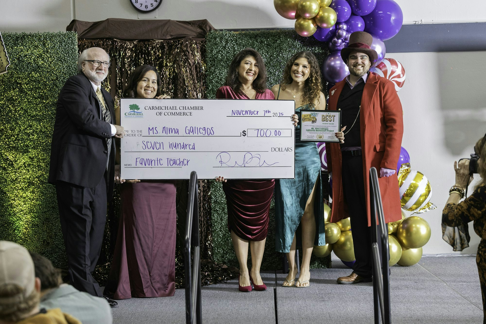 A group celebrates as Alma Gallegos receives a $700 check from the Carmichael Chamber of Commerce for being a favorite teacher.