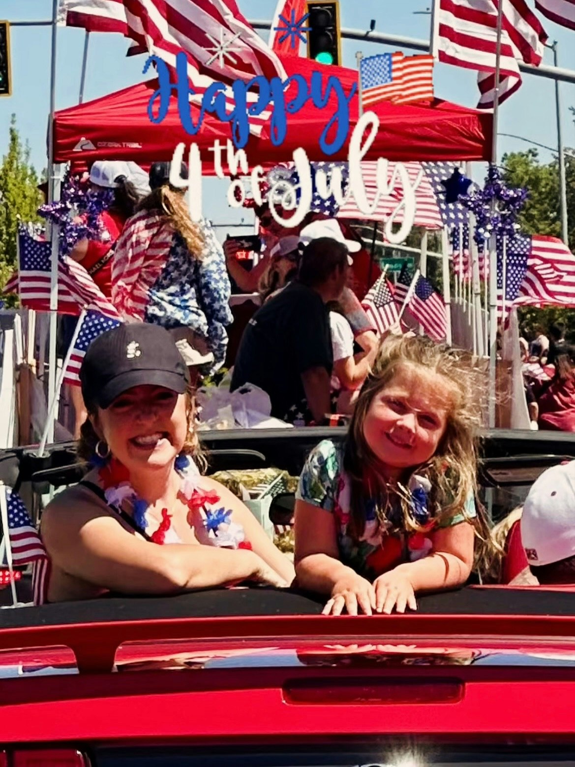 People celebrating the 4th of July in a parade with flags and decorations.