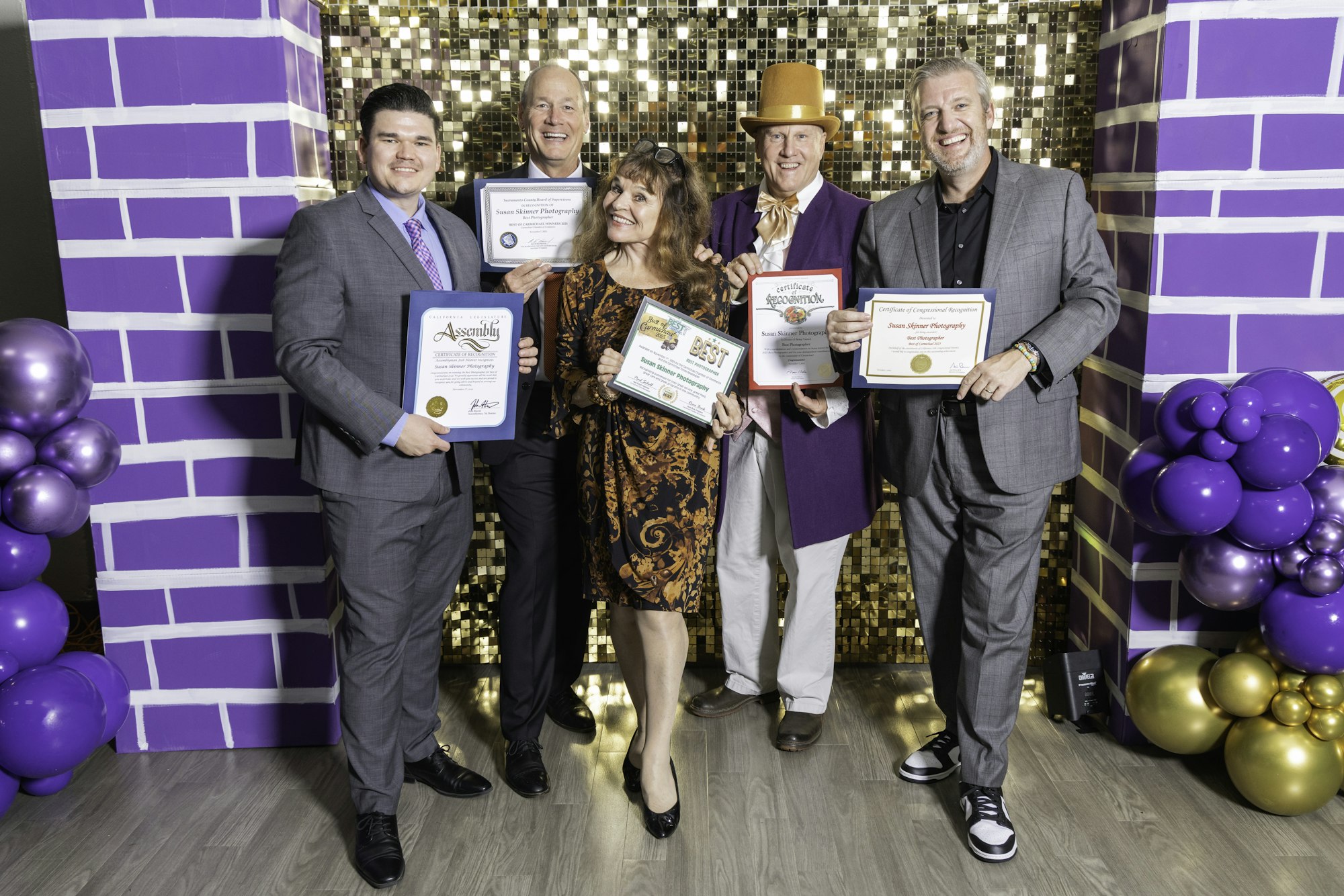 May contain: groupshot, person, purple, people, adult, female, woman, clothing, footwear, shoe, accessories, formal wear, tie, male, man, hat, and balloon