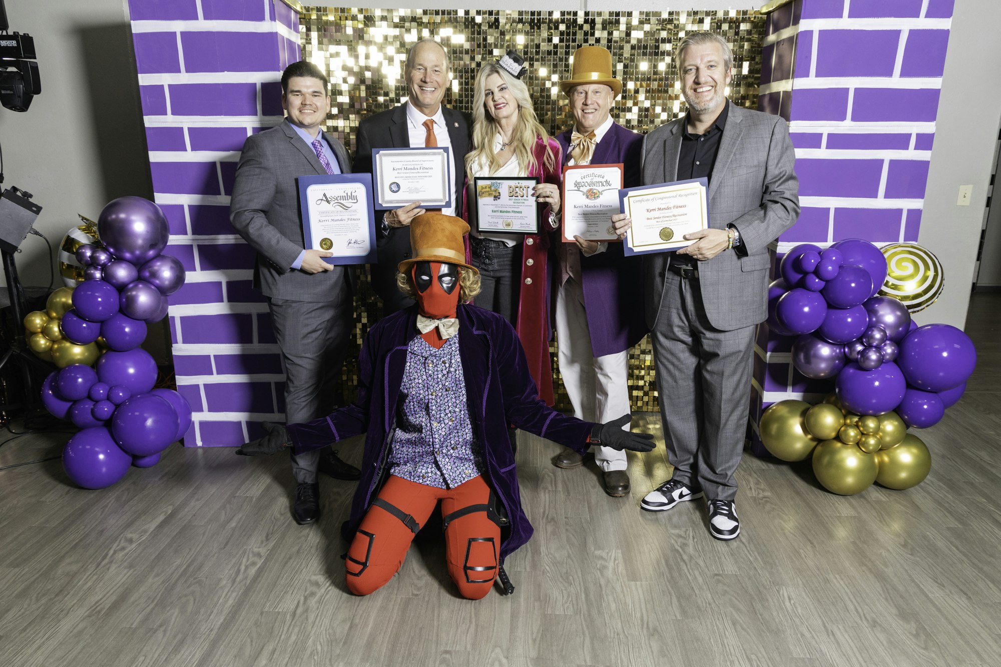 May contain: people, person, purple, clothing, glove, footwear, shoe, accessories, formal wear, tie, adult, male, man, jewelry, ring, balloon, hat, female, woman, groupshot, wristwatch, and necklace