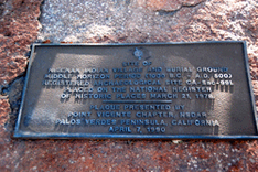 A historical plaque on a stone surface describing an ancient Indian village site and burial ground.