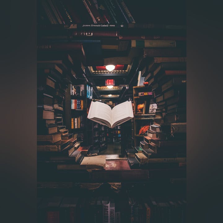 A book tunnel with an open book in the center of a dimly lit library.