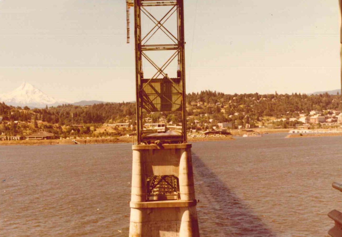 Photo of a bridge tower with landscape and mountain in the background.