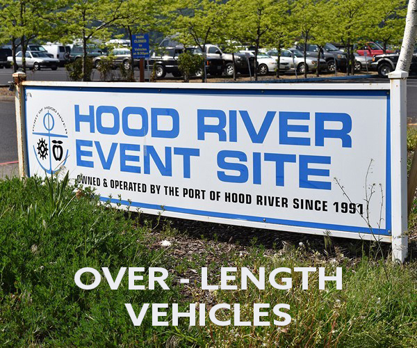 A sign for "Hood River Event Site" and a warning for "over-length vehicles" with a car park in the background.