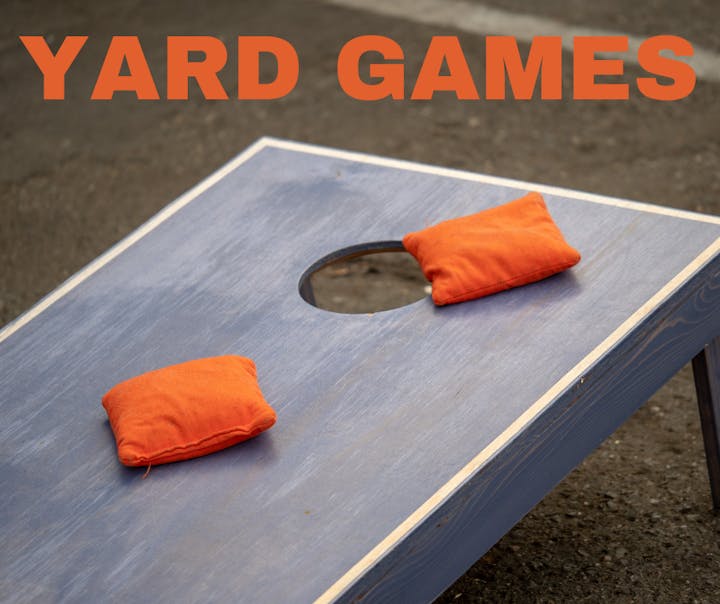 Cornhole game board with orange bean bags and "YARD GAMES" text overlay.