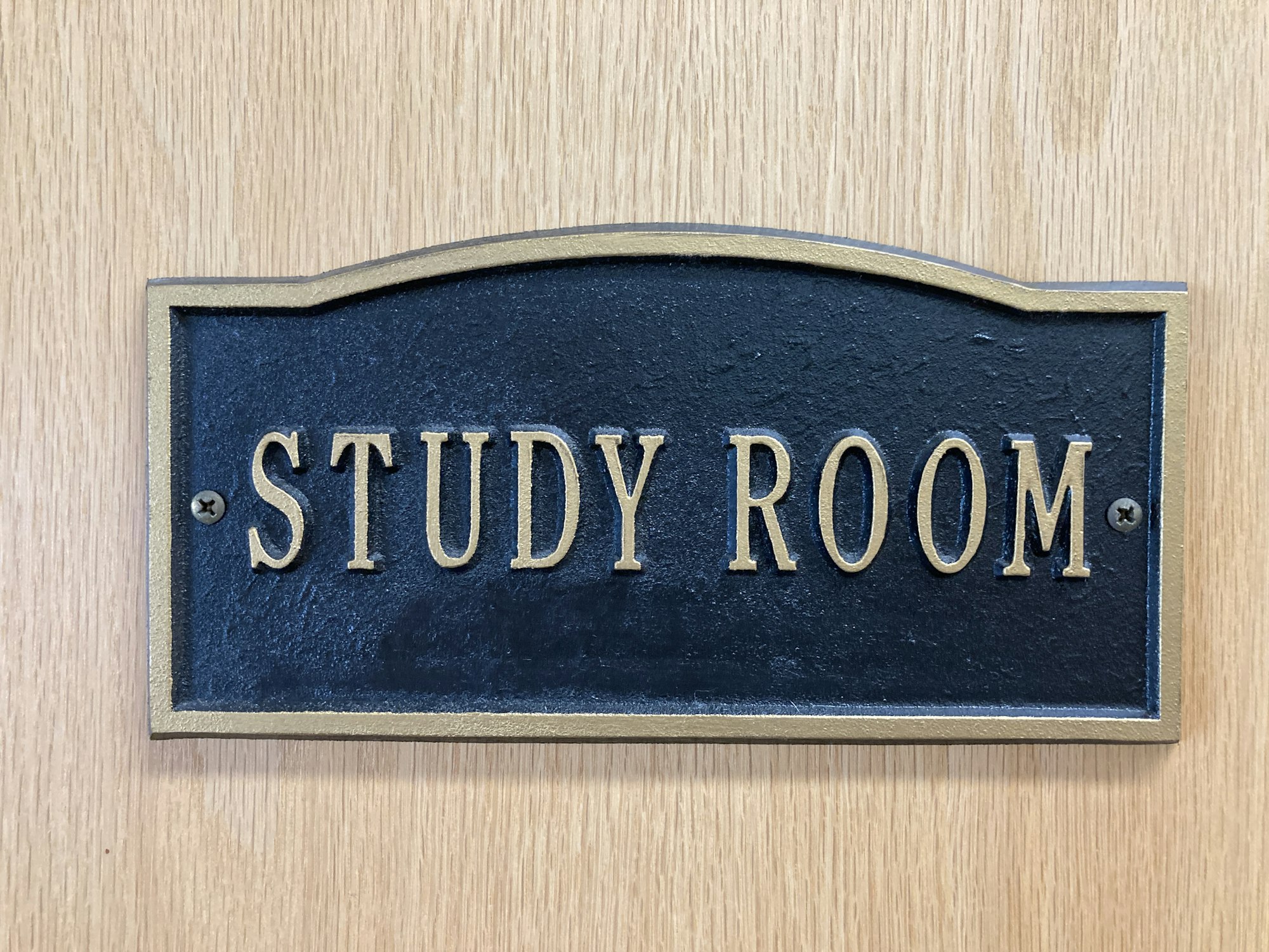 A "STUDY ROOM" sign with gold lettering on a black background, mounted on wood.