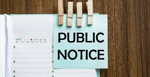 The image shows an open planner with a blue sticky note that reads "PUBLIC NOTICE," held by wooden clips.