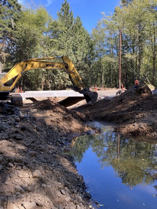 May contain: person, soil, bulldozer, machine, and water