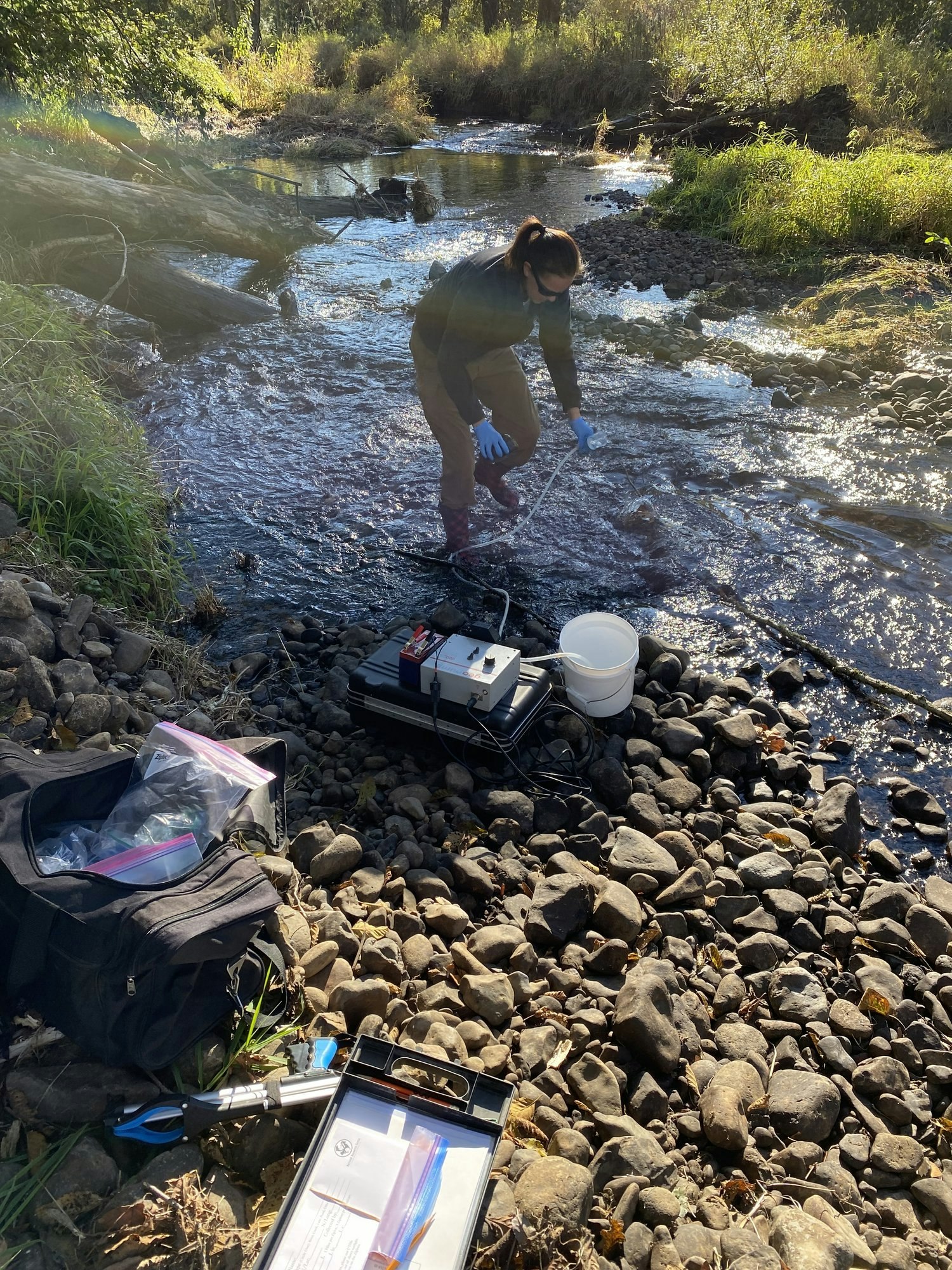 May contain: rock, soil, nature, outdoors, wilderness, plant, vegetation, creek, stream, water, photography, clothing, glove, face, head, person, portrait, land, rainforest, tree, pond, adventure, hiking, leisure activities, footwear, and shoe