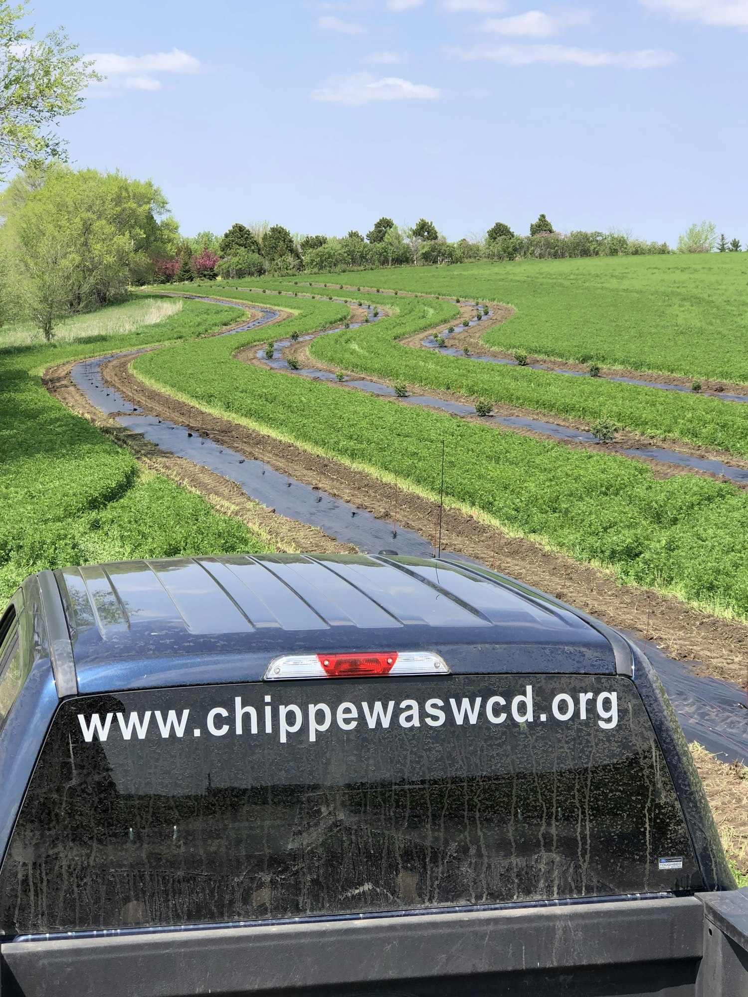 Vehicle with website text, green field, and water channels. Image is rotated 90 degrees.