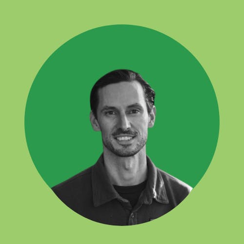 A monochrome image of a smiling man with a beard, set against a green circular background.