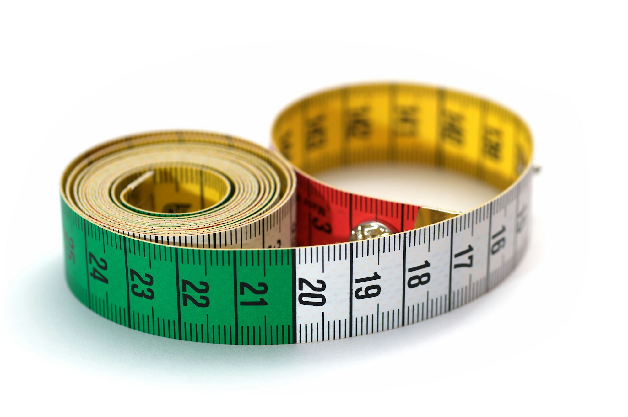 Coiled measuring tape with colored sections of green, red, and yellow.