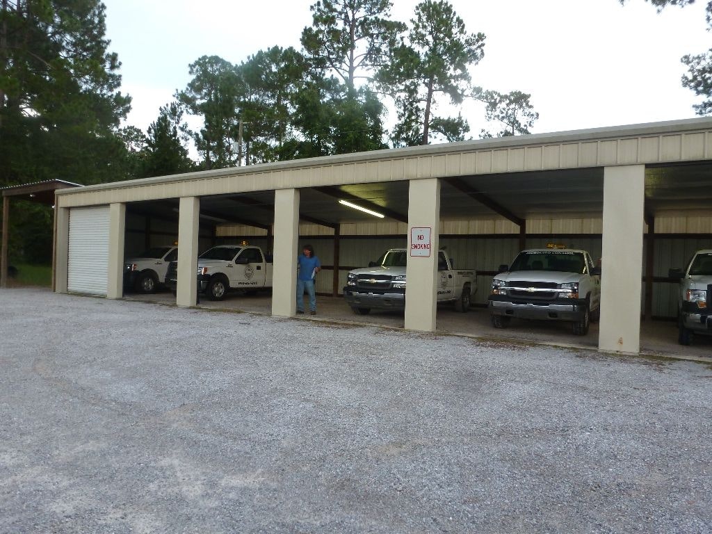 A storage area with several parked trucks and a person standing nearby. A "No Smoking" sign is visible.