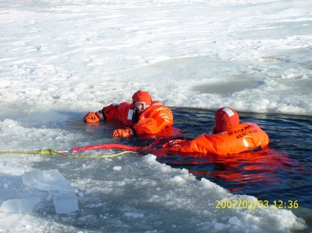 May contain: clothing, lifejacket, vest, person, coat, ice, and jacket