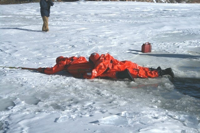 May contain: clothing, coat, lifejacket, vest, ice, person, footwear, shoe, and jacket
