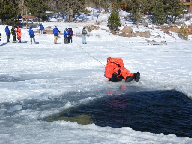 May contain: clothing, lifejacket, vest, person, helmet, footwear, shoe, and glove