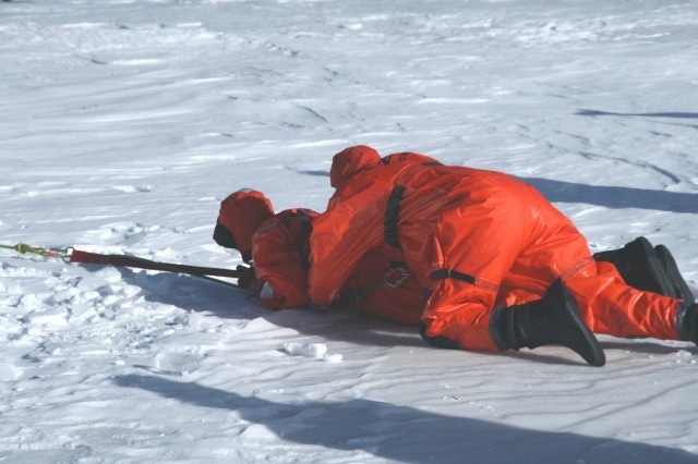 May contain: clothing, coat, footwear, shoe, jacket, person, nature, outdoors, piste, snow, sport, lifejacket, and vest