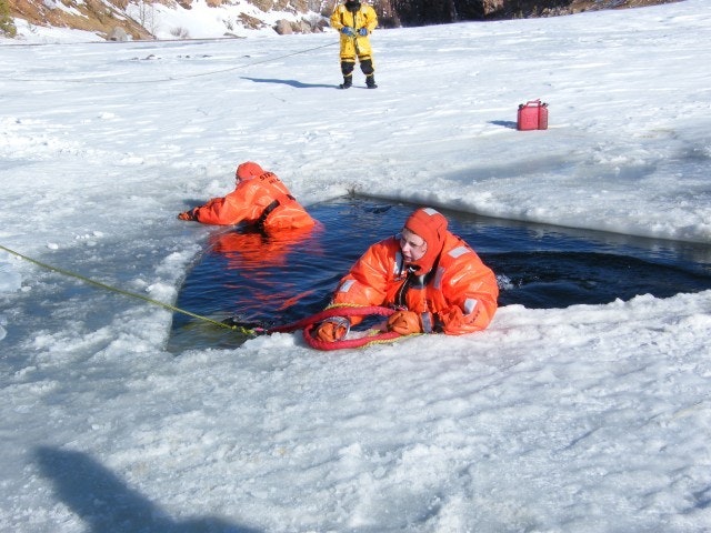 May contain: clothing, lifejacket, vest, ice, person, coat, glove, footwear, and shoe