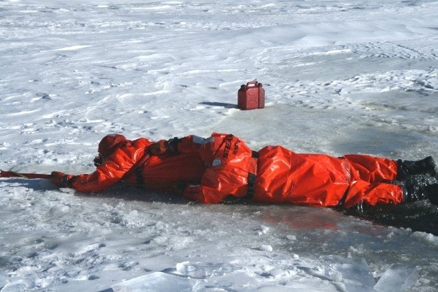 May contain: clothing, coat, lifejacket, vest, glove, person, ice, transportation, vehicle, and watercraft