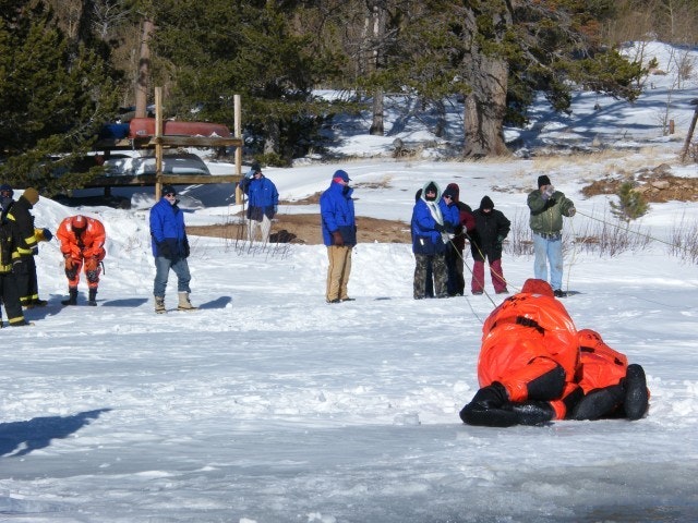 May contain: person, clothing, glove, lifejacket, vest, footwear, shoe, helmet, hat, outdoors, and nature