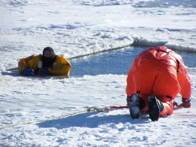 May contain: clothing, coat, lifejacket, vest, glove, jacket, person, adult, male, man, ice, footwear, shoe, and outdoors