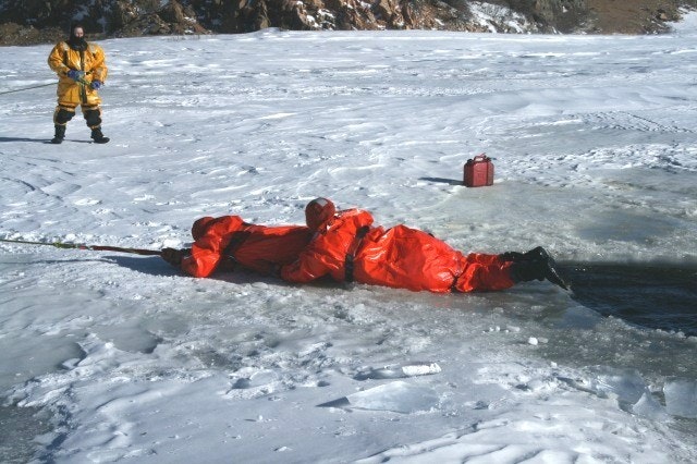 May contain: clothing, coat, glove, person, helmet, lifejacket, vest, footwear, shoe, ice, and jacket