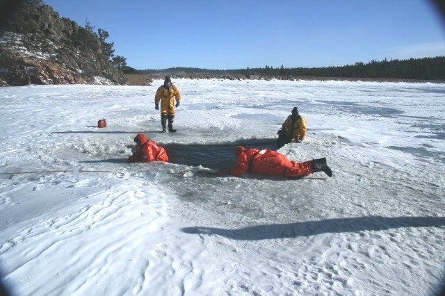 May contain: clothing, lifejacket, vest, person, helmet, footwear, shoe, nature, and outdoors