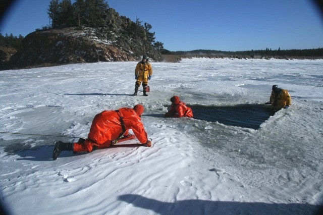 May contain: clothing, lifejacket, vest, coat, person, glove, ice, jacket, helmet, outdoors, and nature