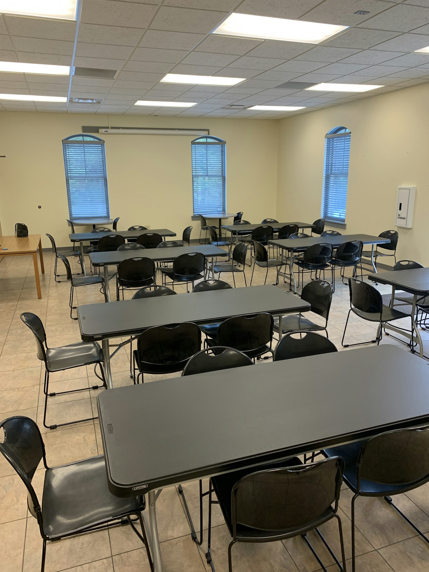 Community Room with 50 black chairs and 10 long tables,