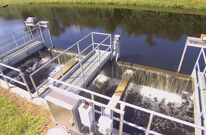 A stormwaterfacility with flowing water, machinery, and gated channels.
