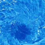 Rippling blue water with a circular pattern, possibly from a drop.