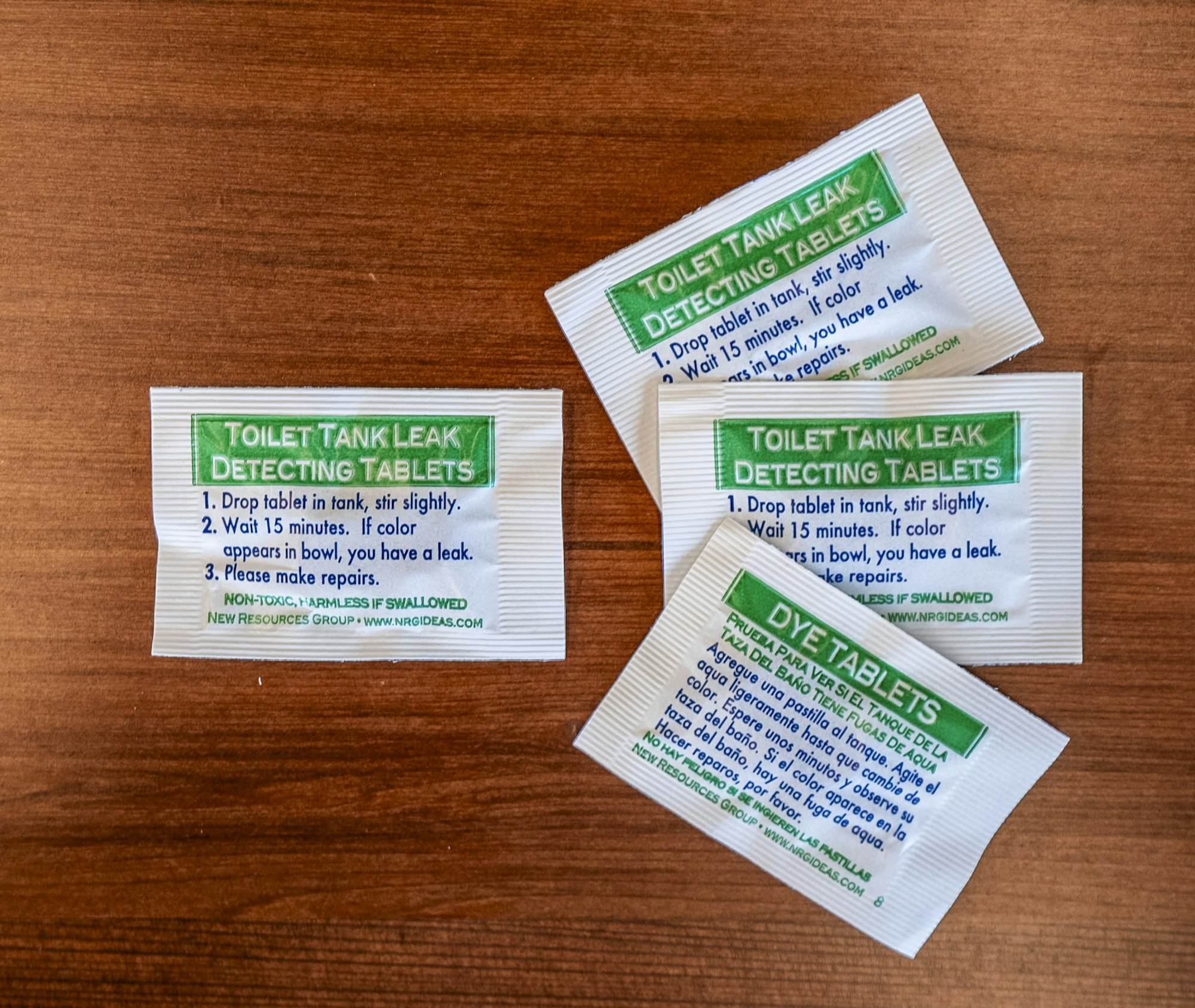 The image shows packets of toilet tank leak detecting tablets with instructions for use.